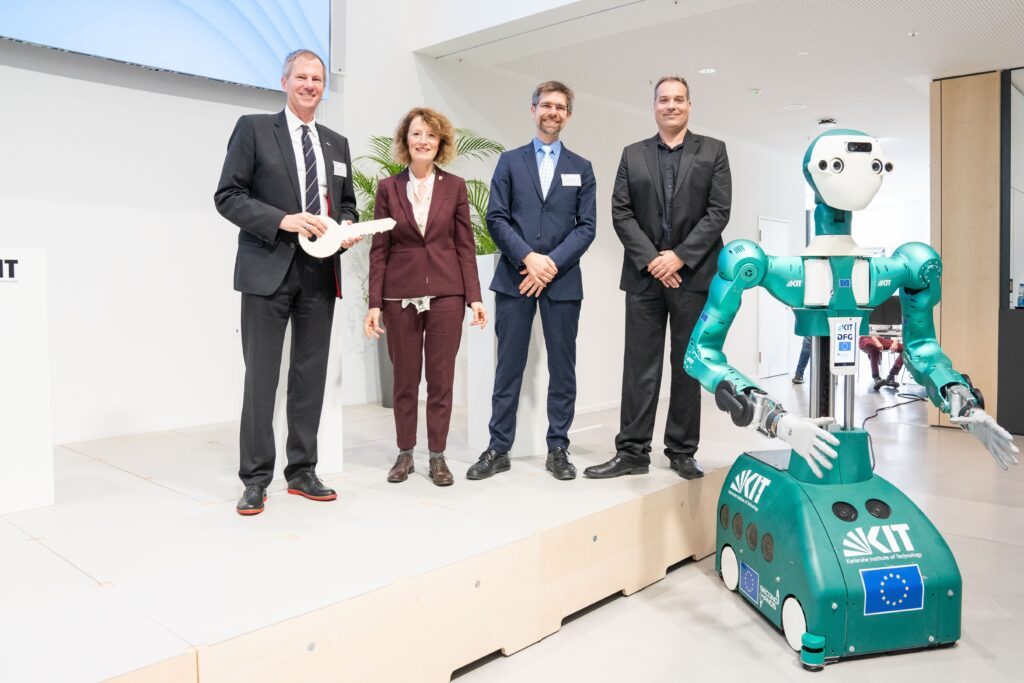 Handing over the keys at InformatiKOM (from left to right): Prof. Oliver Kraft, representing the President of KIT; Ursula Orth, Senior Construction Director of the Karlsruhe Office of the Baden-Württemberg State Office for Property and Construction (VBA); Prof. Rafael Lang, Managing Director Research of the Klaus Tschira Foundation (KTS), architect Sven Bachmann, Bernhardt + Partner architectural office, ARMAR-6. (Photo: Amadeus Bramsiepe, KIT)